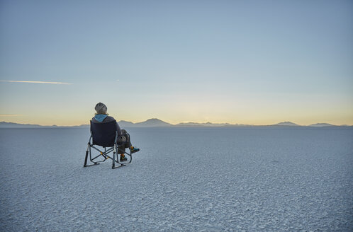 Frau im Campingstuhl sitzend, auf Salzwiese, mit Blick auf Aussicht, Salar de Uyuni, Uyuni, Oruro, Bolivien, Südamerika - CUF02622