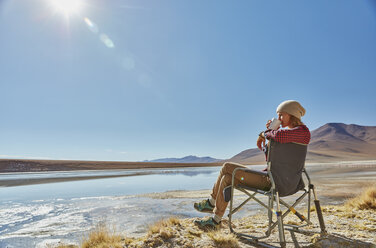 Frau im Campingstuhl sitzend, mit Blick auf die Aussicht, Salar de Chalviri, Chalviri, Oruro, Bolivien, Südamerika - CUF02625