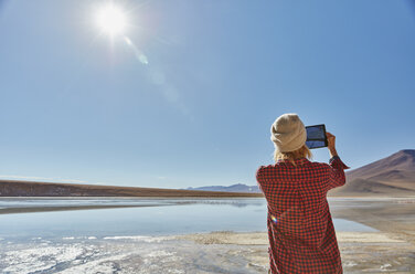 Frau beim Fotografieren der Landschaft, mit digitalem Tablet, Salar de Chalviri, Chalviri, Oruro, Bolivien, Südamerika - CUF02626
