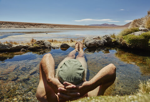 Man relaxing in water pool, rear view, Salar de Chiguana, Chiguana, Potosi, Bolivia, South America - CUF02631