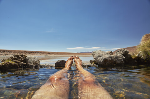 Mann entspannt sich im Wasserbecken, niedriger Abschnitt, Salar de Chiguana, Chiguana, Potosi, Bolivien, Südamerika, lizenzfreies Stockfoto