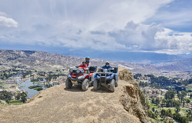 Mother and sons on top of mountain, using quad bikes, La Paz, Bolivia, South America - CUF02635