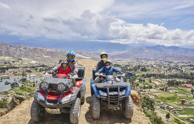 Family on top of mountain, using quad bikes, La Paz, Bolivia, South America - CUF02639