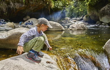 Boy crouching on rock beside water pool, Ventilla, La Paz, Bolivia, South America - CUF02647