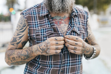 Tattooed male hipster fastening shirt buttons, cropped - CUF02677