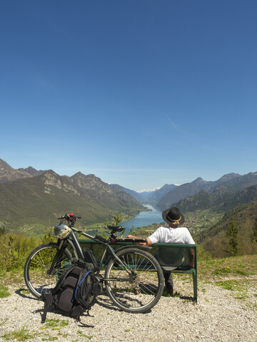 Italien, Lombardei, Älterer Wanderer mit Blick auf den Idrosee, Adamello Alpen, Parco Naturale Adamello Brenta, lizenzfreies Stockfoto