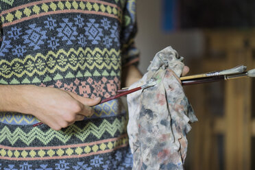 Männlicher Künstler beim Reinigen von Pinseln in einem Künstleratelier, Mittelteil - CUF02741