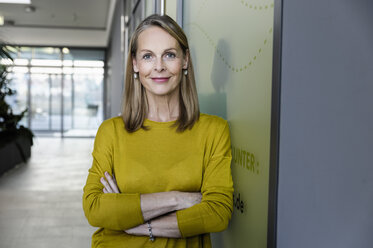 Portrait of confident mature businesswoman in office corridor - CUF02817