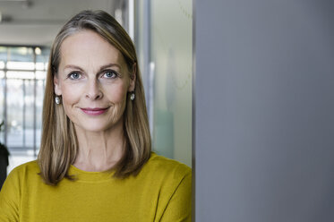 Portrait of confident mature businesswoman in office corridor, head and shoulders - CUF02818