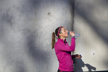 Young woman drinking water from water bottle - CUF02884