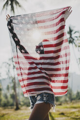 Junge Frau hält amerikanische Flagge hoch, Krabi, Thailand - CUF02937