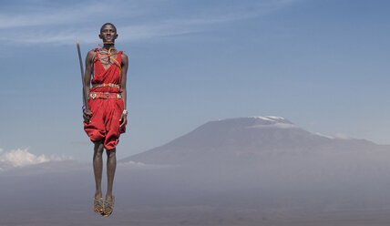 Massai-Mann in traditioneller Kleidung beim Sprung vor dem Kilimandscharo, Amboseli, Rift Valley, Kenia - CUF02939
