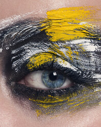 Studio portrait of blue eyed woman with painted face, close up of eye - CUF02955