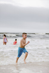 Junge, der am Strand am Wasser entlang läuft, Dauphin Island, Alabama, USA - CUF02958