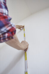 Person measuring white wall - CUF02984