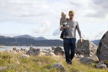 Mann trägt Sohn am Fjord, Aure, More og Romsdal, Norwegen - CUF03008