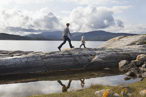 Mann und Sohn beim Spaziergang auf einer Fjord-Felsformation, Aure, More og Romsdal, Norwegen - CUF03009