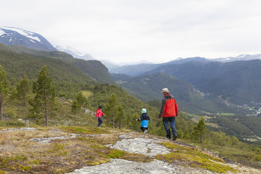 Mann mit Söhnen beim Wandern in Berglandschaft, Rückansicht, Jotunheimen Nationalpark, Lom, Oppland, Norwegen - CUF03019