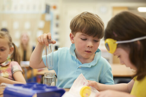 Grundschüler und Mädchen machen Reagenzglas-Experiment im Klassenzimmer - CUF03043