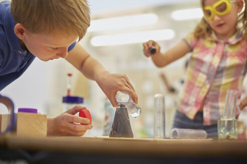 Grundschüler und Mädchen machen Reagenzglas-Experiment im Klassenzimmer - CUF03046