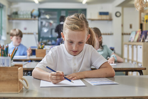 Schülerin beim Schreiben im Unterricht in der Grundschule - CUF03060