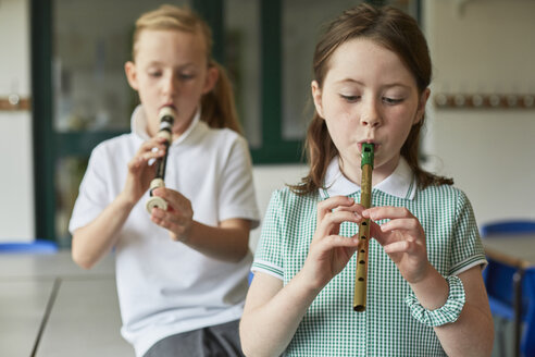 Schulmädchen spielen Blockflöten im Klassenzimmer einer Grundschule - CUF03062