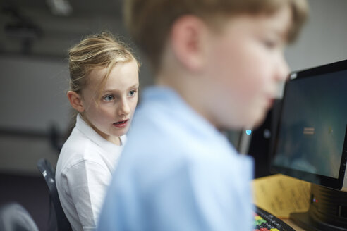 Schülerin und Junge benutzen Computer im Klassenzimmer einer Grundschule - CUF03092