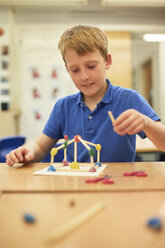 Schoolboy making ball and stick model in classroom at primary school - CUF03097