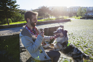 Hund mit Pfoten auf dem Schoß des Besitzers im Park - CUF03119