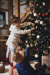 Junges Mädchen und Junge beim Schmücken des Weihnachtsbaums - CUF03134