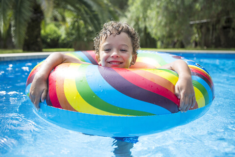 Junge mit aufblasbarem Ring im Freibad, Porträt, lizenzfreies Stockfoto