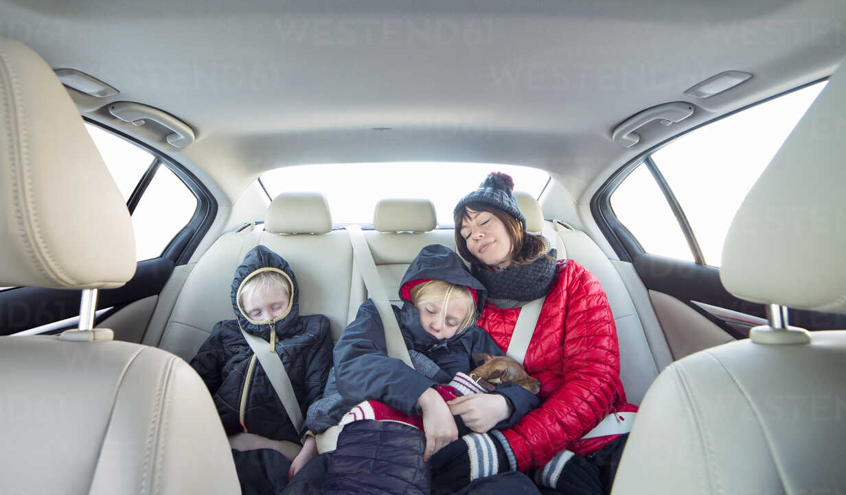 Mutter und Kinder schlafen im Auto, lizenzfreies Stockfoto