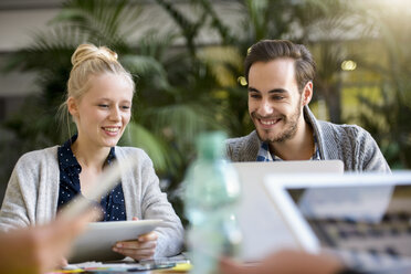 Männlicher und weiblicher Designer mit Blick auf den Laptop auf dem Schreibtisch im Designstudio - CUF03271