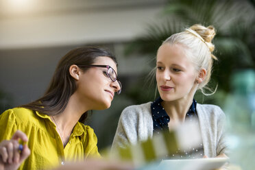 Two female designers meeting at design studio desk - CUF03272