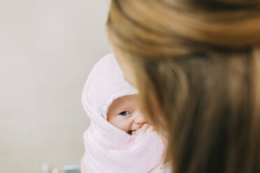 Mother holding baby daughter wrapped in towel - CUF03290