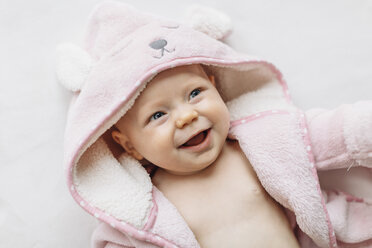 Portrait of baby girl in hooded towel looking away smiling - CUF03296