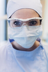 Porträt einer Zahnärztin, die eine chirurgische Maske und eine Schutzbrille trägt, Nahaufnahme - CUF03360