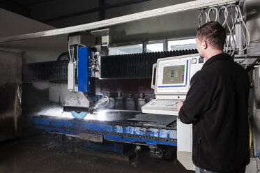 Steinmetz bei der Arbeit mit der CNC-Maschine in seiner Werkstatt - CVF00460