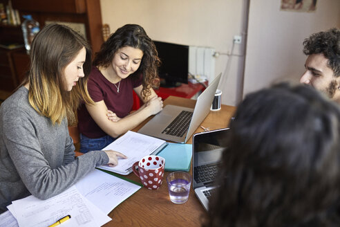Vier Schüler am Schreibtisch arbeiten und lernen gemeinsam - JRFF01621