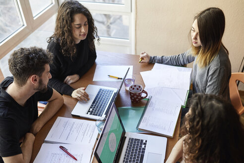 Vier Schüler am Schreibtisch arbeiten und lernen gemeinsam - JRFF01622