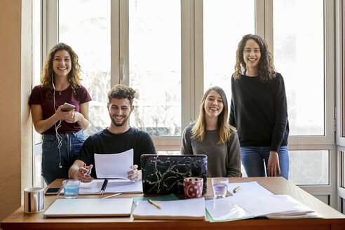 Porträt von vier glücklichen Studenten am Schreibtisch und am Fenster - JRFF01623