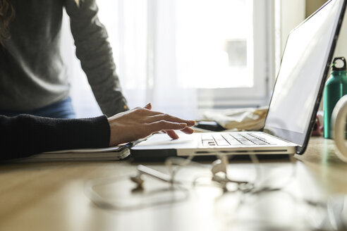 Nahaufnahme von zwei Frauen, die zu Hause am Schreibtisch einen Laptop benutzen - JRFF01627