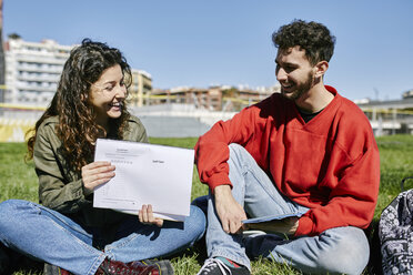 Zwei schüchterne Studenten sitzen im Park und lernen gemeinsam - JRFF01635