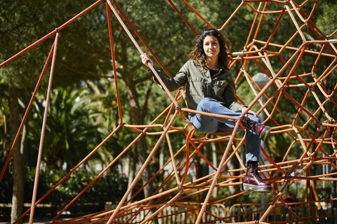 Portrait of young woman on a climbing frame on a playground stock photo