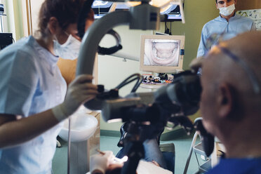 Dentist and dental nurse carrying out procedure on patient - CUF03454