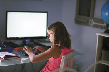 Junges Mädchen sitzt am Schreibtisch, macht Hausaufgaben, benutzt einen Computer - CUF03514
