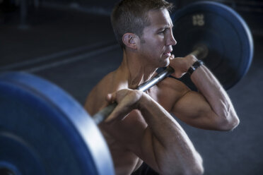 Mann trainiert in einem Fitnessstudio mit einer Langhantel in der Hocke - CUF03531
