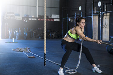 Woman exercising in gymnasium, sled training - CUF03536