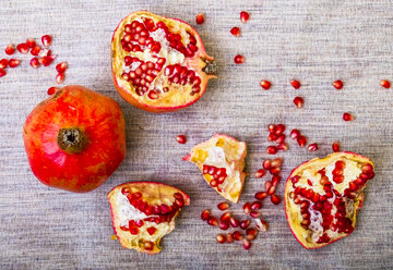Pomegranate pieces and seeds on table - CUF03591
