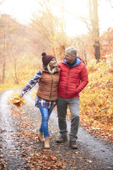 Älteres Paar, das auf einem ländlichen Weg spazieren geht, im Herbst - CUF03605